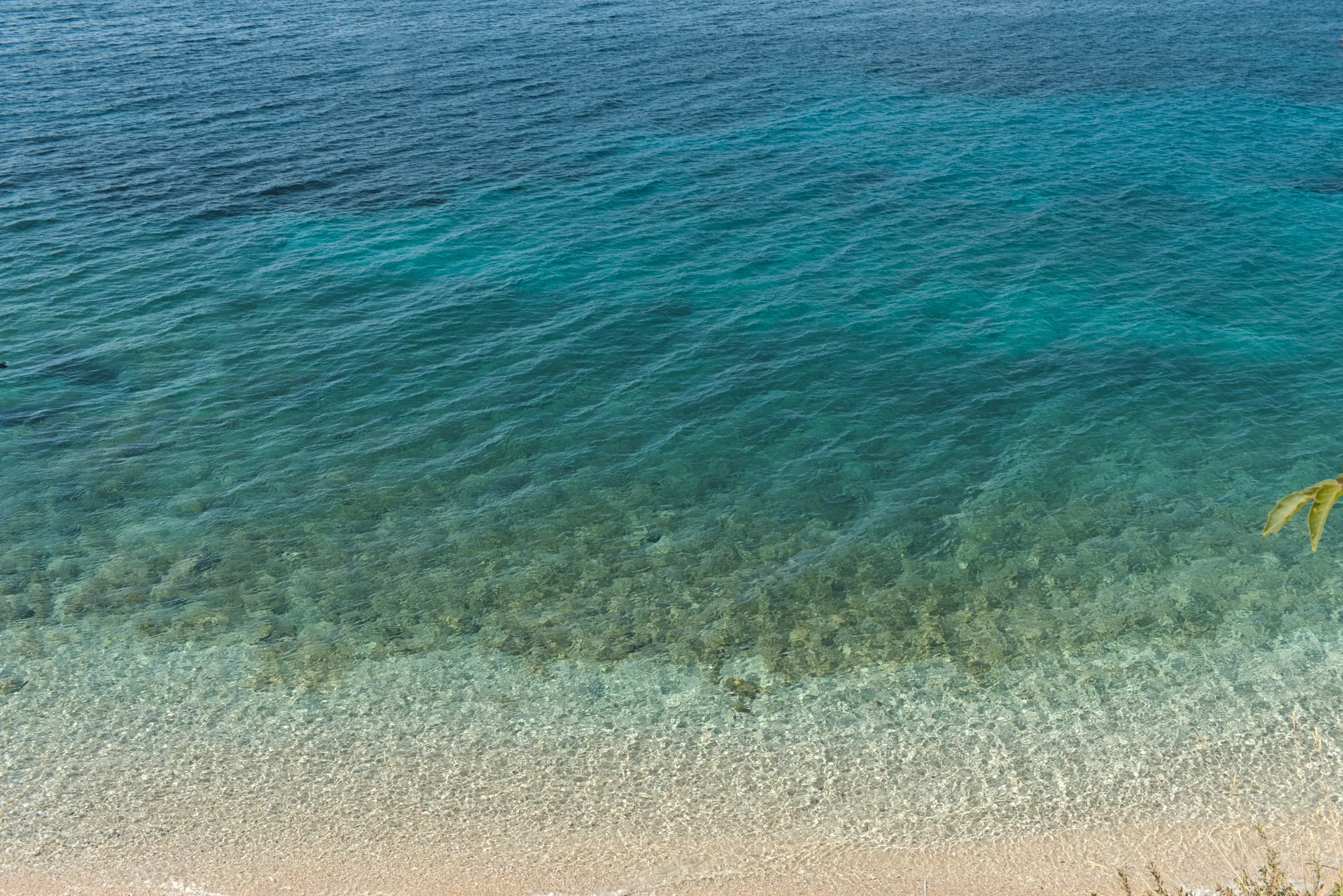 Klares Wasser über dem Kiesstrand bei Zavala